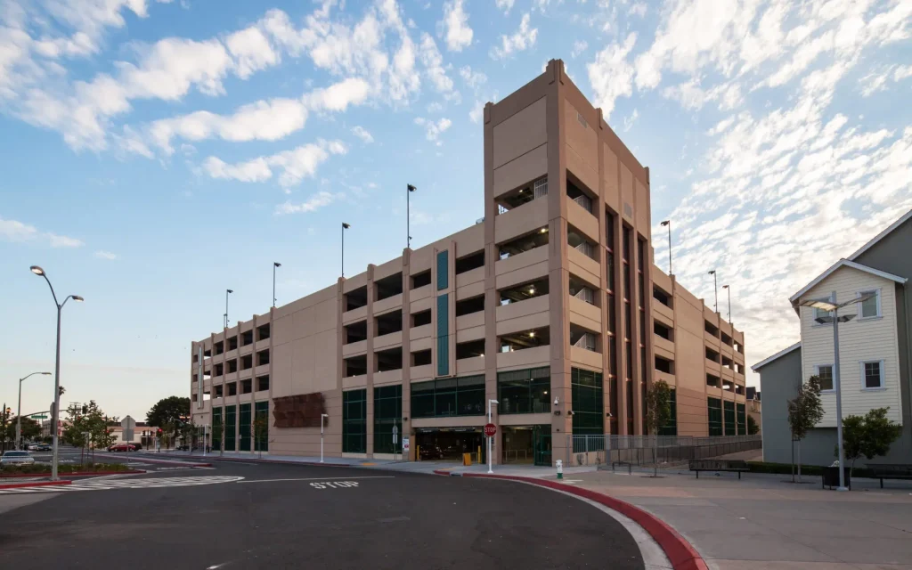 A parking garage with lots of windows and a sidewalk.