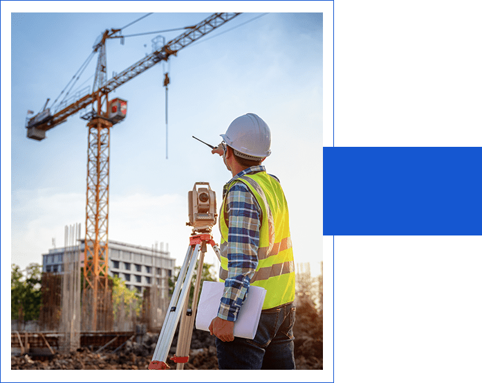 A man in safety vest and hard hat using surveying equipment.