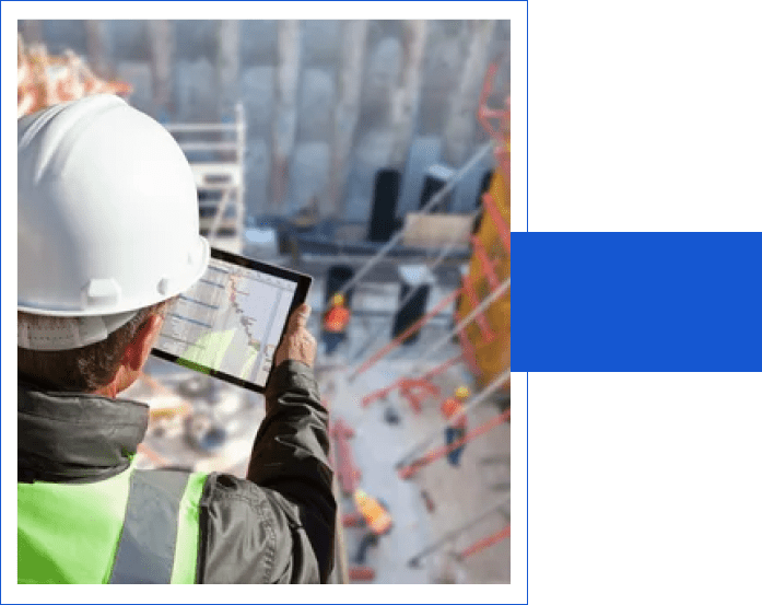 A man in hard hat holding up a tablet.