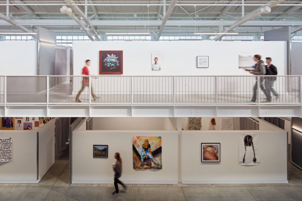 A woman walking down the stairs in an art gallery.