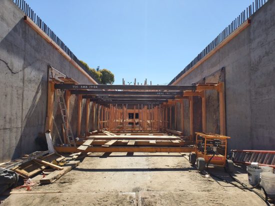 A construction site with many wooden beams and a blue sky.