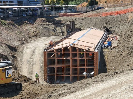 A construction site with workers working on the ground.