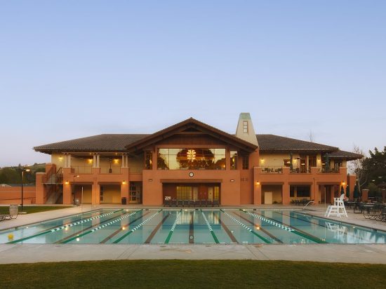 A large swimming pool with a building in the background.