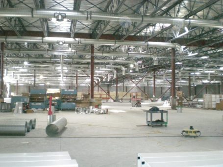 A large warehouse with many metal pipes and beams.