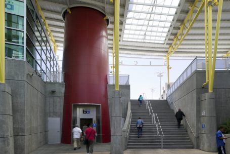 A red tower with people walking up the stairs.