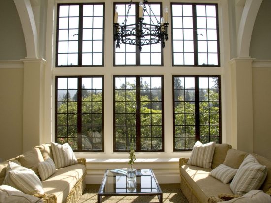 A living room with two large windows and couches