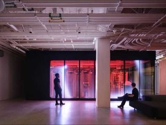 Two people sitting in a room with red lights.