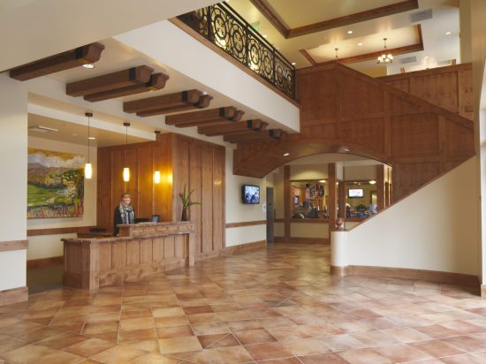 A lobby with a staircase and a reception desk.