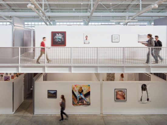 A woman walking down the stairs in an art gallery.